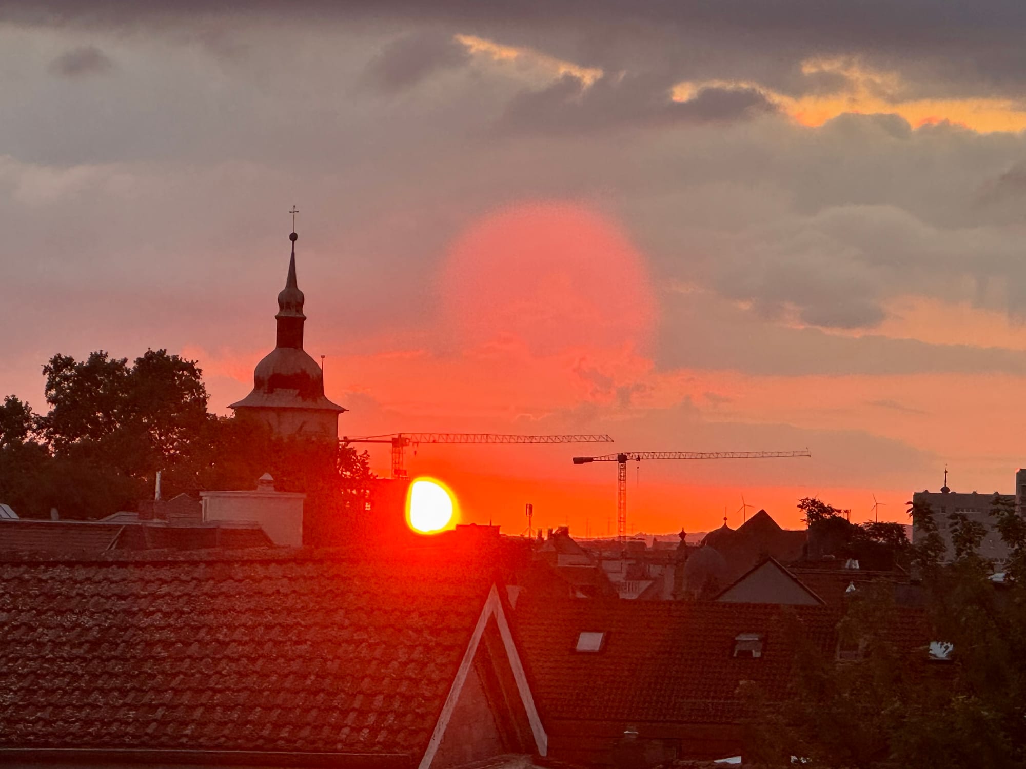 Sonnenaufgang über der Stadt Ende Juli 2026 - Kräne und Kirchen