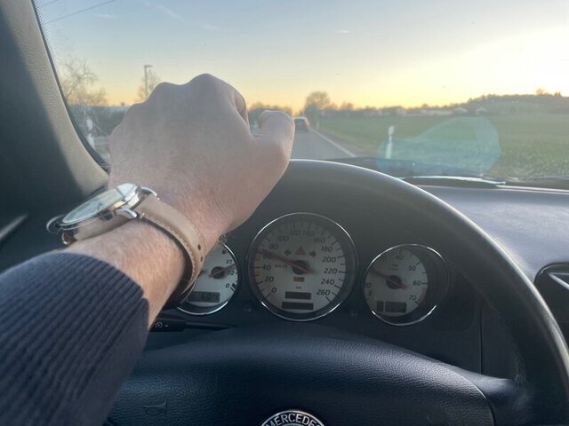 Herr Montag fährt im Roadster eine Landstraße entlang