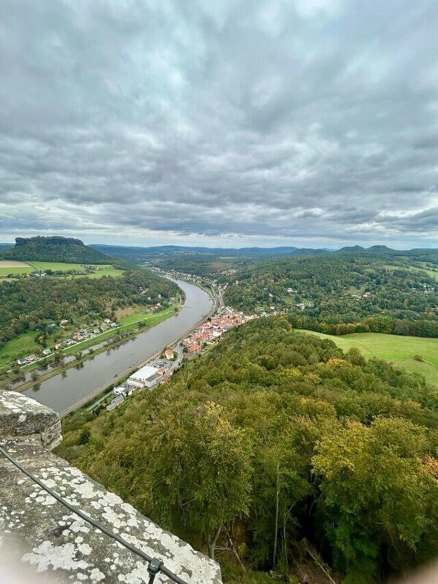 Blick von der Festung Königstein über das Land, der Himmel ist wolkenbehangen, der Fluss und die Landschaft sind weit