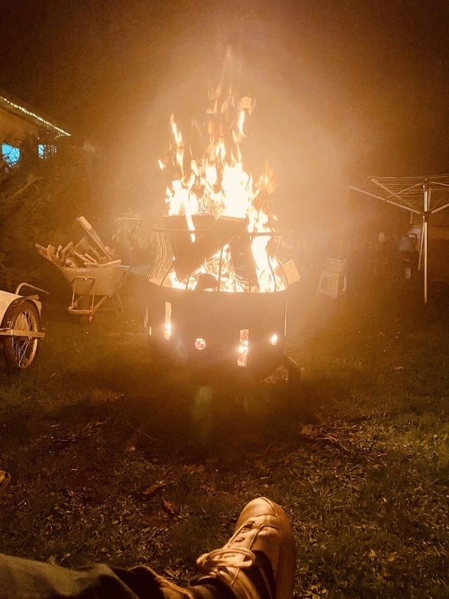 Eine sogenannte Feuertrommel brennt vor sich hin. Ein Fuß ragt ins Bild.