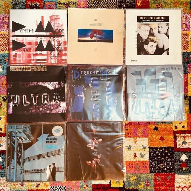Auf einem Teppich liegen 9 verschiedene Schallplatten, alle von der Band Depeche Mode